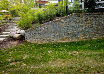 Expertly-landscaped LawnScapes outdoor project with decorative plants and stonework.